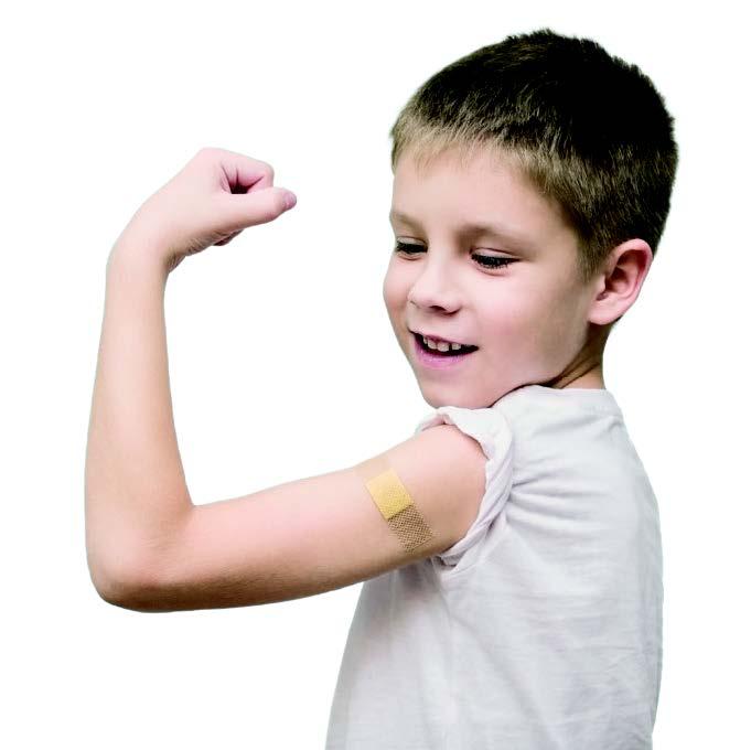 a boy of around 8 years old flexes his arm, which has a plaster on it after a vaccination