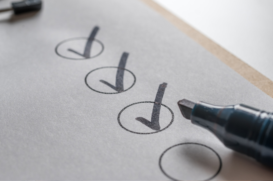 4 young people are sitting in a row in a classroom working at computers. They are all deep in concentration and working individually.