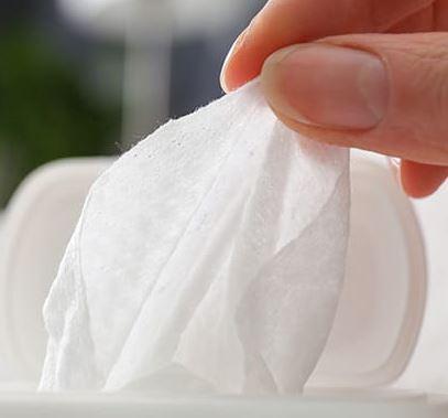 Close up of fingers grabbing an alochol wipe.