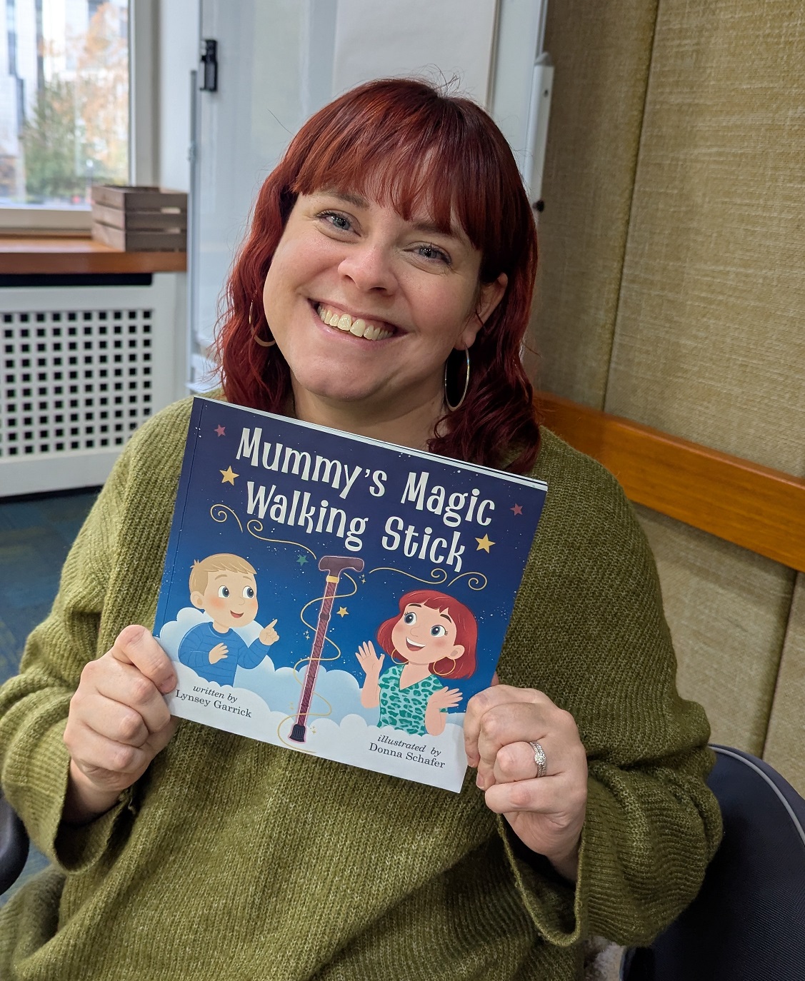 Headshot of Lynsey Garrick holding her book.