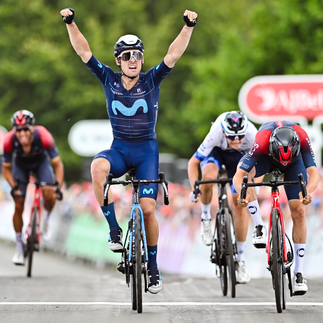 Pro cyclist celebrating winning a race, with hands in the air after crossing the finishing line