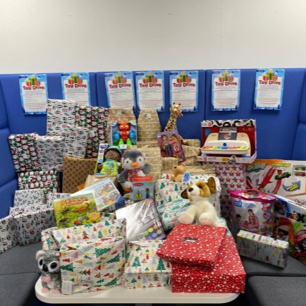 Pile of presents wrapped up and some unwrapped toys and games.