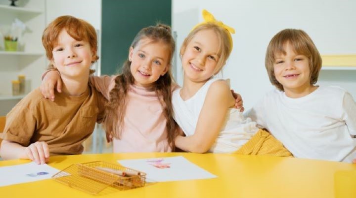 Children sat together smiling in classroom