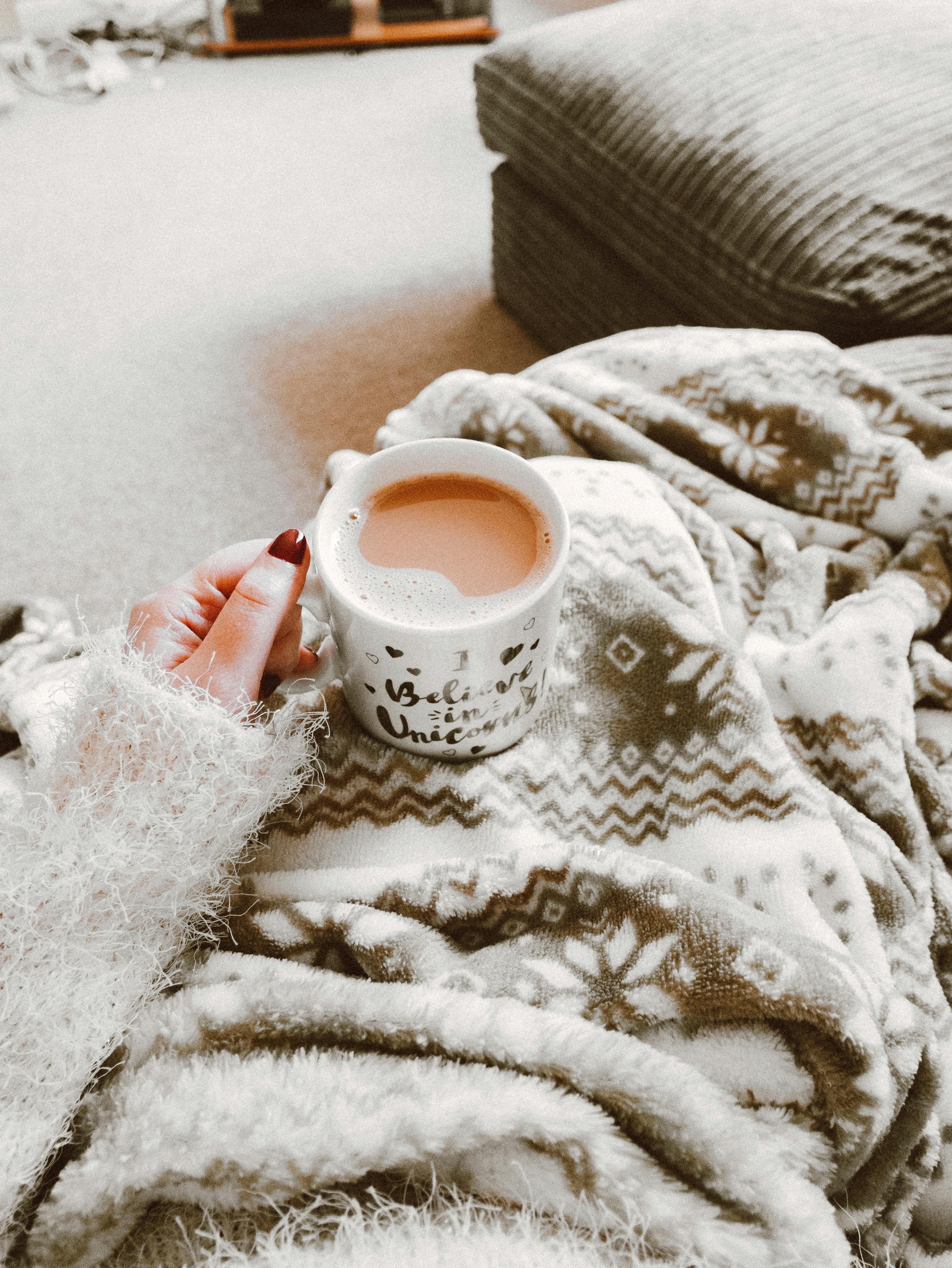 staying warm under blanket with a hot drink