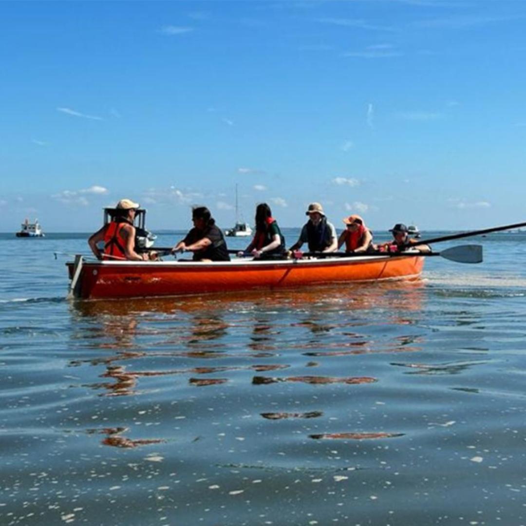 Five people rowing on the water of the Thames Estuary